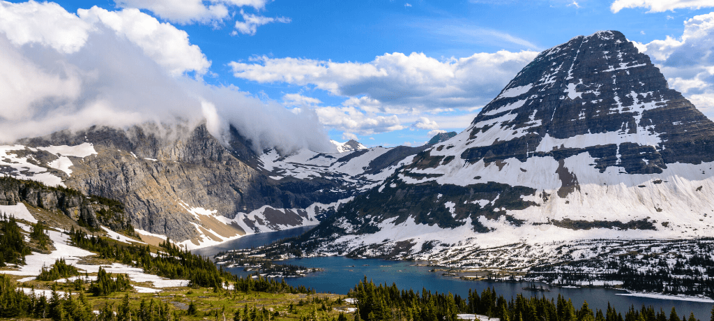 Beautiful view of snowcapped mountains and a teal lake in Glacier National Park