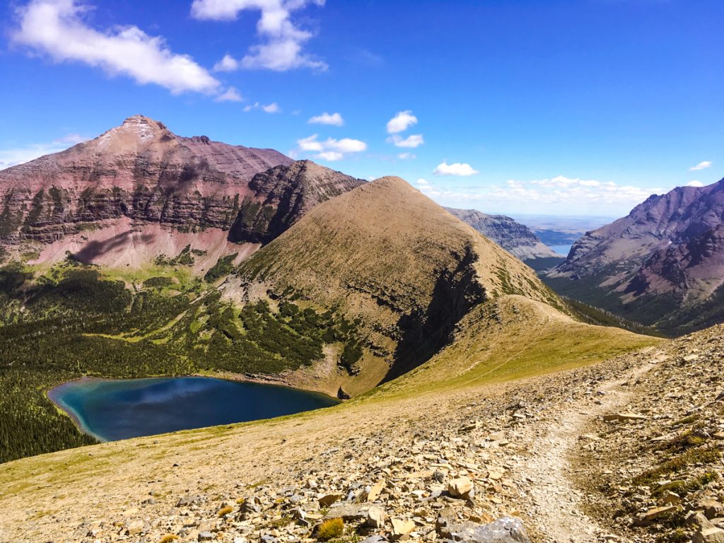 Hiking trail with lake and mountain views in Glacier National Park.