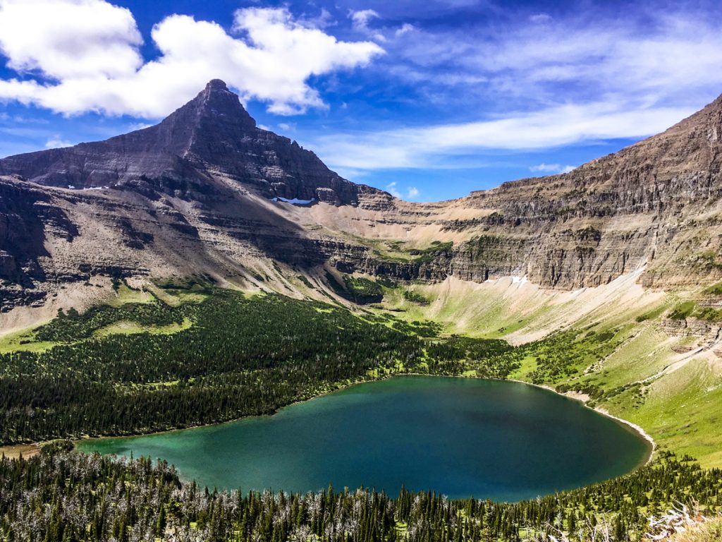 Mountain peak and teal lake seen from Pitamaken Trail in Glacier National Park.